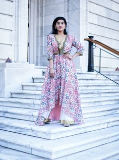 a woman in a long dress standing on some steps