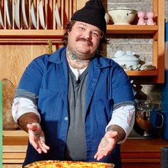 a man holding a pizza on top of a pan