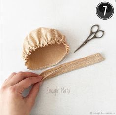 a person is holding a pair of scissors next to some fabric and other crafting supplies