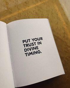 an open book with the words put your trust in divine time on it's cover