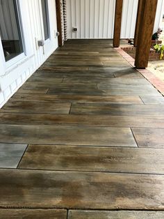 an outdoor patio with wood flooring and white siding