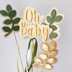 there is a cake topper that says oh baby on it with leaves and ribbons