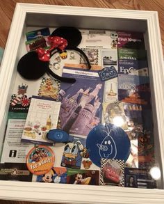 a mickey mouse ear and other items are on display in a shadow box at disney world