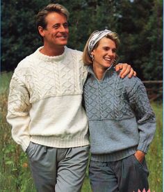 a man and woman standing next to each other in front of some tall green grass