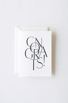 a white card with black lettering that says congrats and it is on top of a table