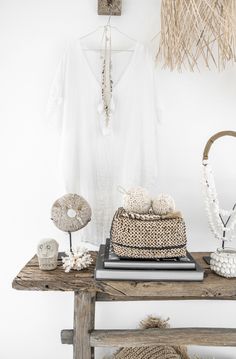 a wooden table topped with a basket next to a white shirt and other items on top of it