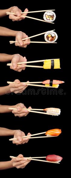 hand holding chopsticks with sushi on black background royalty images and stock photos