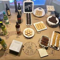 a table topped with lots of different types of food and wine bottles next to each other