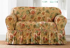 a floral couch with ruffles on the arms and back, sitting in front of a white background