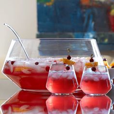 three glasses filled with red liquid and garnished with cherries on the rim