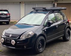 a small black car parked in front of a building