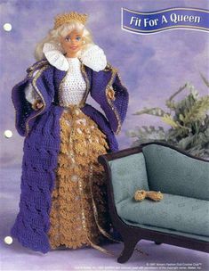 the doll is wearing a purple dress with gold trimmings and a tiara