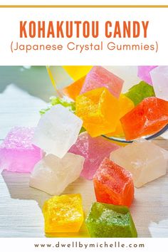 colorful gummy bears sitting on top of a table next to a glass bowl filled with jelly