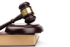 a wooden judge's gavel sitting on top of a book with a white background