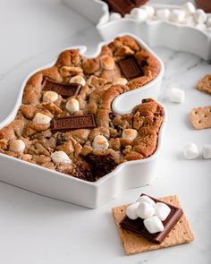 a cookie shaped like the letter s with marshmallows and chocolate on top