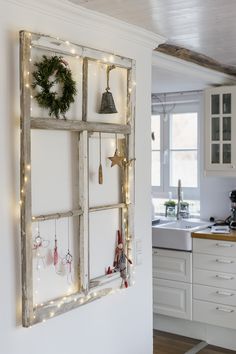 an old window is decorated with christmas lights and ornaments for the holiday season in this kitchen