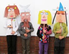 four children wearing paper masks standing in front of a brick wall