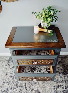 a small table with a plant on top and a book in the drawer next to it