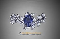 an elegant blue ring with leaves and diamonds on the front, set in 18k white gold