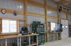 the inside of a garage with lots of tools and workbenches on tables in front of windows