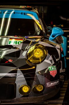 the front end of a racing car with its lights on