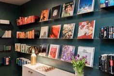 there are many books on the shelves in this room, including one that has a vase with flowers