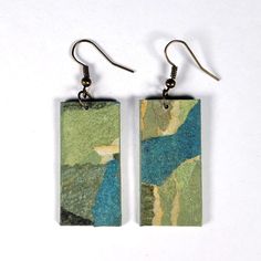 pair of earrings with blue and green painting on them