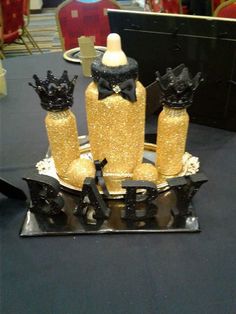 there are three bottles on the table with gold glitters and black bows around them