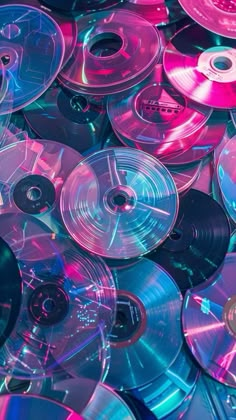 many different colored cds are stacked together in this photo, with one being pink and the other is blue