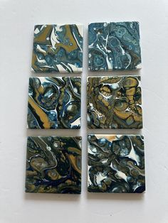 four pieces of art made out of marbles on a white surface with blue and yellow colors