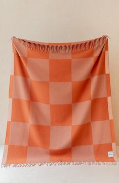 an orange and white checkered blanket hanging on a wall