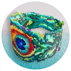 a bracelet made out of colorful beads on top of a blue circle with a white background