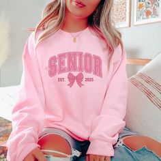 Senior 2025 Sweatshirt, Coquette Senior Class Of 2025 Sweatshirt, Senior Pink Bow Sweatshirt, Graduation Gift, High School Shirt Information - Material: 100% cotton; fabric material may vary depending on color and size - Printing technique: DTG - Location: United States Fulfillment time - Processing Time: 1-5 business days - Shipping lines: USPS, UPS, DHL - Shipping time (US): 2-9 business days - Shipping time (WW): 10-25 business days Care Instructions Wash items inside out in cold water, do no Pink Varsity Sweatshirt For College, Pink Varsity Long Sleeve Top, Pink Crew Neck Sweatshirt For College, Pink Long Sleeve Varsity Top, Collegiate Pink Crew Neck Top, Pink College Sweatshirt With Letter Print, Pink Varsity College Tops, Pink Varsity Top For College, Pink Letter Print Sweatshirt For College