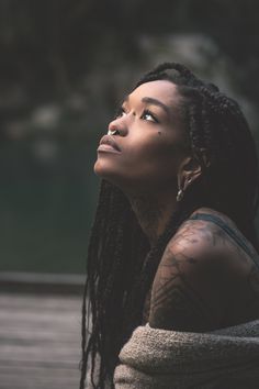 a woman with dreadlocks looking up into the sky