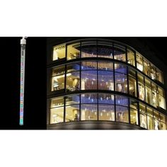 a large building with lots of windows and christmas decorations on it's side at night