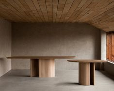 two round wooden tables in an empty room