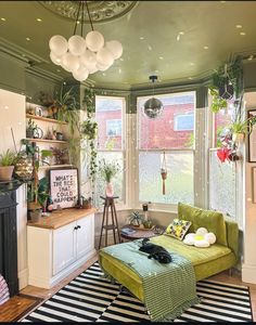 a living room filled with furniture and lots of plants on top of windowsills