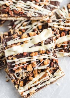 chocolate barkle bars with white icing drizzled on top and chopped walnuts