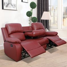 a red reclining couch sitting in front of a window