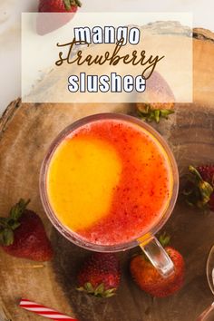 a drink in a glass with strawberries around it and the words mango strawberry slushie