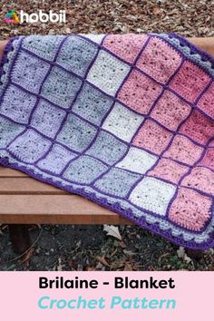 a crocheted blanket sitting on top of a wooden bench