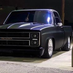 an old black car parked on the street at night