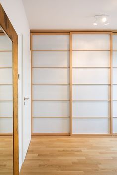 an empty room with white walls and wooden floors