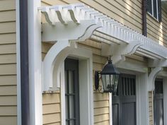 a lamp hanging on the side of a house next to a light pole and windows