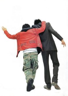 two men in suits are hugging each other while one man is wearing a red jacket