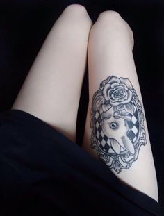 two legs with tattoos on them and one has a woman's face in the middle