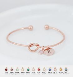 an image of a bracelet with two charms on it and four different colored stones in the middle