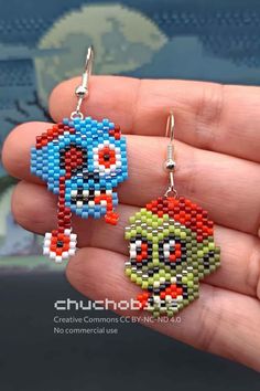 a pair of earrings made out of legos is being held in someone's hand