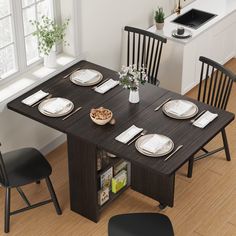 a dining table with chairs and plates on it