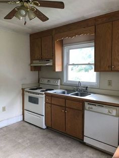 an empty kitchen with white appliances and wood cabinets